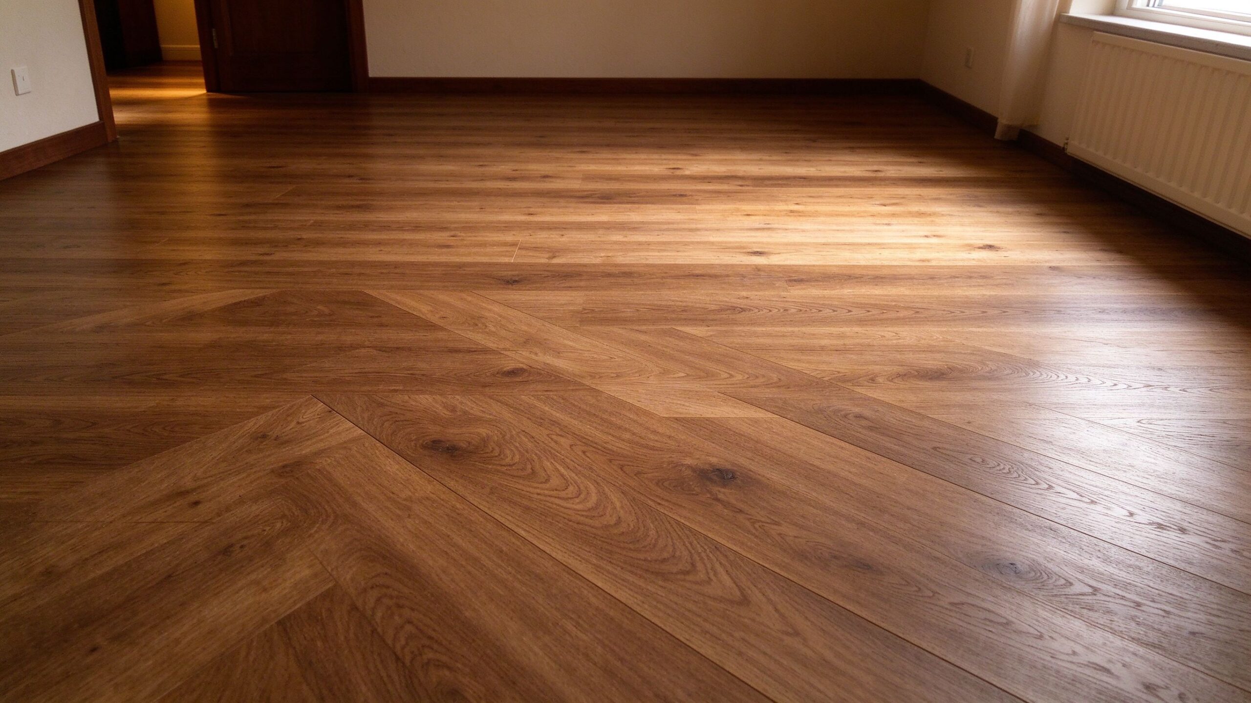 Herringbone wood flooring installed in bright interior